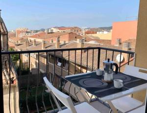 a table with two cups and a tea kettle on a balcony at 3 Bedroom Jazz Apartment with Private Terrace in Terrassa