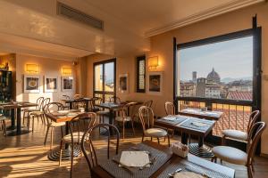 a restaurant with tables and chairs and a balcony at B&B Hotel Firenze Pitti Palace al Ponte Vecchio in Florence