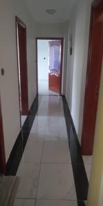 un couloir vide avec une porte et du carrelage dans l'établissement Studios-Appartements meublés Makepé BM, à Douala