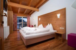 a bedroom with a bed with white pillows on it at Hotel Tannenberg in Saalbach-Hinterglemm