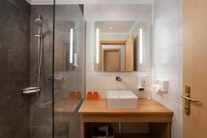 La salle de bains est pourvue d'un lavabo et d'une douche. dans l'établissement Hotel Tannenberg, à Saalbach-Hinterglemm