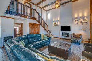 a living room with a leather couch and a staircase at Miramar in Holden Beach