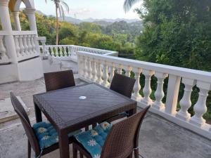 a table and chairs on the balcony of a house at Red Hassell Manor in Port Antonio