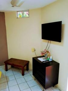 sala de estar con mesa y TV de pantalla plana en Apartamentos osuna, en Mazatlán
