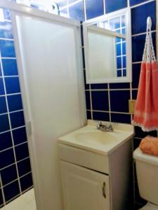 y baño con lavabo, aseo y espejo. en Apartamentos osuna, en Mazatlán