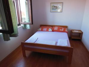 a small bedroom with a bed and two windows at Apartments Paladina in Mandre