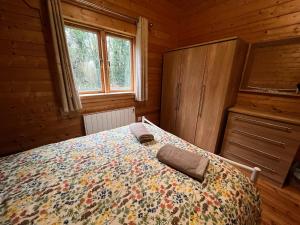 a bedroom with a bed in a wooden cabin at Kingfisher Lodge, Lake Pochard in South Cerney