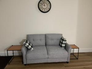 a living room with a couch and a clock on the wall at Downtown Home - Close to Topgolf, Ravens Stadium, Orioles Park, UM Baltimore in Baltimore +65 photos
