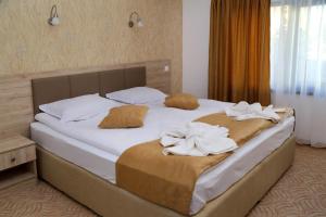 1 dormitorio con 1 cama grande y toallas. en Guest House Saint Petka en Veliko Tŭrnovo