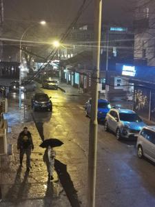 dwoje ludzi spacerujących ulicą z parasolką w obiekcie Stars Aspava Blue HOSTEL w mieście Podgorica