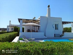 a villa with a swimming pool and a house at Sea Breeze in Lachania