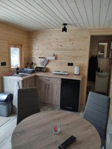 a wooden kitchen with a table and a sink at Maringotky Šumava in Sušice