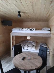 Habitación pequeña con mesa y litera en Maringotky Šumava, en Sušice