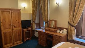 a room with a bedroom with a bed and a mirror at Crown Hotel in Downham Market