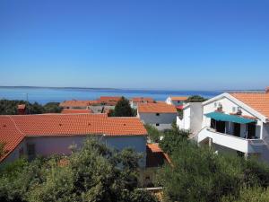 a view of the roofs of houses and the ocean at Apartments Paladina in Mandre