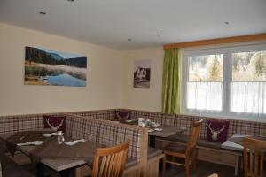 a restaurant with tables and chairs and a window at Pension Waldheim in Mauterndorf