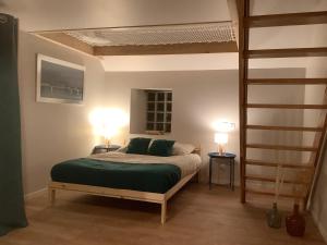 a bedroom with a bed with green sheets and two lamps at Le filet Cherbourgeois in Cherbourg en Cotentin