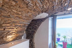 une pièce avec un mur en pierre et une fenêtre dans l'établissement casa dei zitelli studio de charme avec jardin et terrasse, à Brando