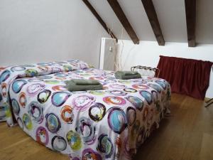 Bett mit farbenfroher Bettdecke in einem Zimmer in der Unterkunft B&B Eden in Trient