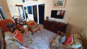ein Wohnzimmer mit Sofa und Fernseher in der Unterkunft Solar Oliveira in Angra dos Reis