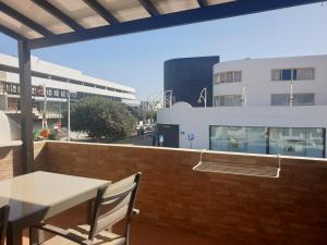 una mesa y sillas en un balcón con un edificio en Casa Rosita, en Puerto del Carmen