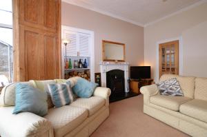 a living room with two couches and a fireplace at Kames View Apartment in Tighnabruaich
