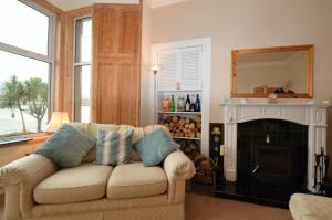 a living room with a couch and a fireplace at Kames View Apartment in Tighnabruaich