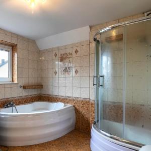a bathroom with a tub and a glass shower at Mieszkania I studio I pokoje z łazienkami in Gdańsk