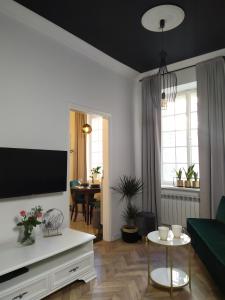 NDM Apartament في وارسو: غرفة معيشة مع أريكة وتلفزيون
