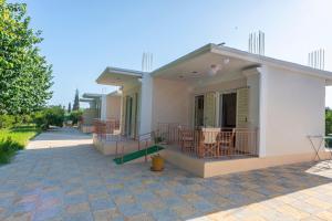 a small white house with a patio at Anesis Residence in Drepana