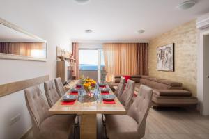 una sala da pranzo con un lungo tavolo e sedie di Mintos Luxury Resort a Podstrana