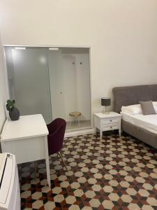 a bedroom with a bed and a desk and a table at DOMUS IOLE appartamento nel centro storico in Catania