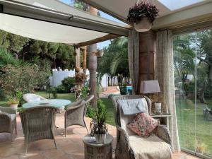 un patio con sombrilla, mesa y sillas en Finca Filpi en Chiclana de la Frontera