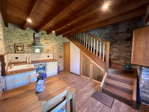 una cocina con fregadero y una escalera en una casa en Casa rural LA TORRE recién rehabilitada. en Las Herrerías