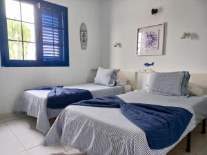 アリエタにあるSunrise Casita del Marのベッドルーム1室(青と白のシーツが備わるベッド2台付)