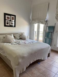1 dormitorio con cama blanca y ventana en Cherrywood House en Dubái