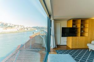 a room with a balcony with a view of the water at LUXURY VIEWS by YoursPorto in Vila Nova de Gaia