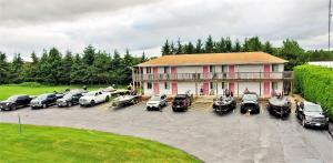 a large building with cars parked in a parking lot at Knights Inn Colonial Fireside Inn in Pembroke
