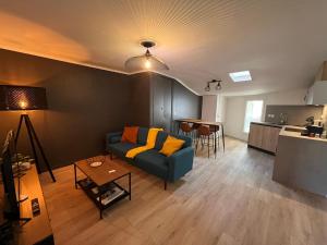 un soggiorno con divano blu e una cucina di Le Briand ad Aix en Provence