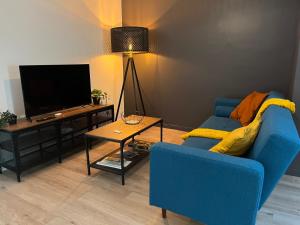 un soggiorno con divano blu e TV di Le Briand ad Aix en Provence