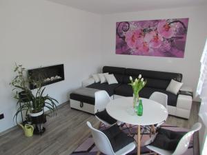 a living room with a couch and a table and chairs at Apartament Ella in Polanica-Zdrój