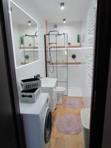 a bathroom with a washing machine and a washer and dryer at Apartament Ella in Polanica-Zdrój