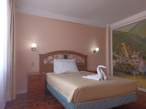 a bedroom with a bed with a stuffed swan on it at RIXAA Hotels in La Paz