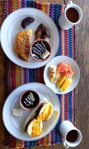 three plates of breakfast foods on a table with coffee at Vista Encantada in Villa Canales