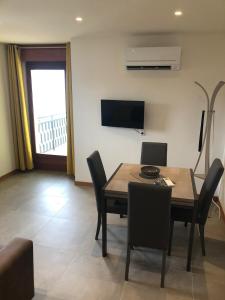 a dining room with a table and chairs and a television at CASA COSTA AL SOLE in Lazise