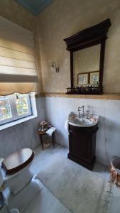 a bathroom with a sink and a toilet and a mirror at Palio Limani (Old Harbour) in Spetses +50 photos