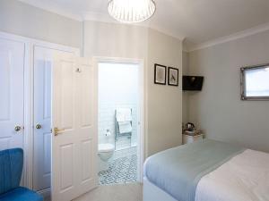 a bedroom with a bed and a bathroom with a toilet at The Castleton in Swanage
