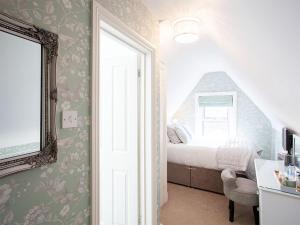 a small bedroom with a bed and a window at The Castleton in Swanage