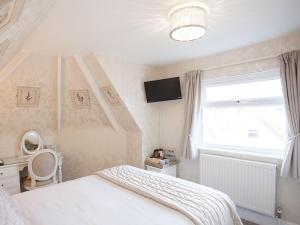 a bedroom with a white bed and a window at The Castleton in Swanage