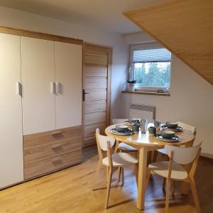 a dining room with a wooden table and chairs at Apartament Grel in Nowy Targ +5 photos
